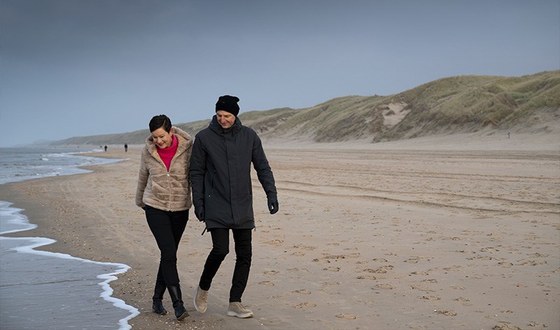 Stel wandelt over het strand van Castricum in de winter