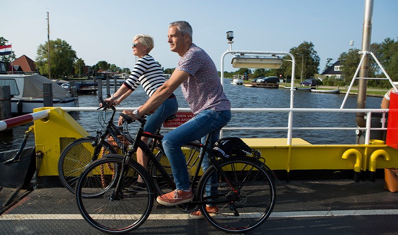 Foto van fietsers op een pont