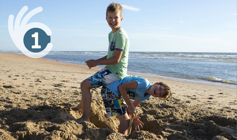 Jungen spielen am Strand